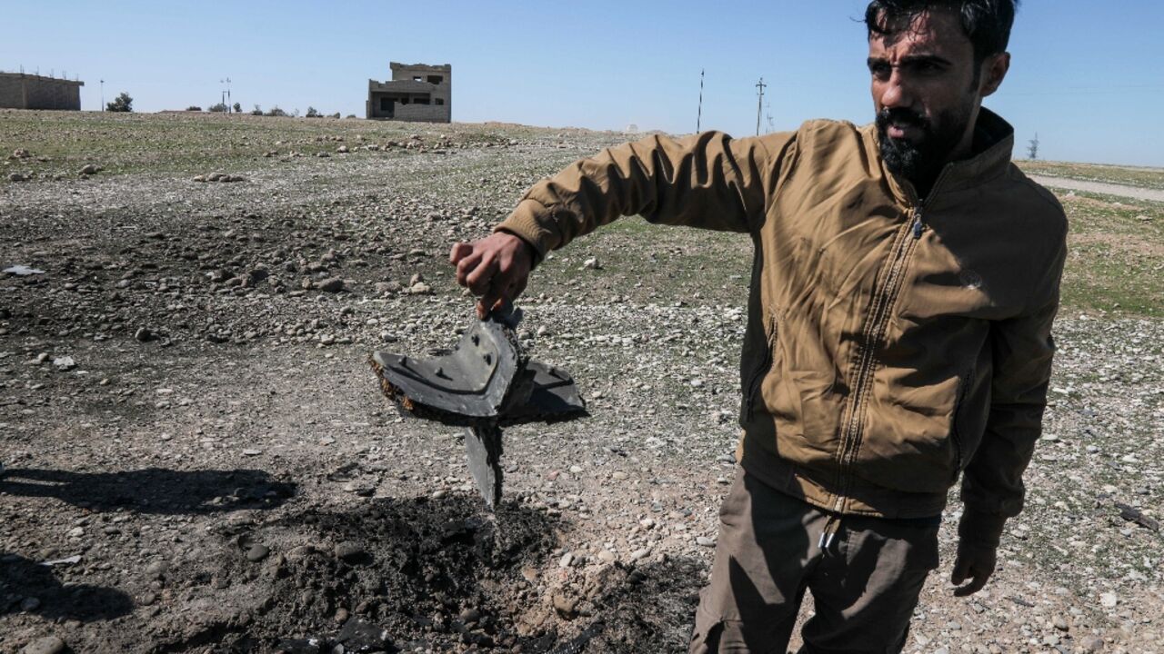 A man shows the remains of a drone at the airport in Iraq's Erbil 
