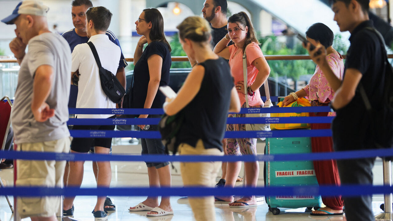 Stranded passengers stand in line at the Qatar Airways customer service at I Gusti Ngurah Rai International Airport after flights to Doha, Dubai, and Abu Dhabi were cancelled following strikes on Iran launched by the United States and Israel, in Kuta, Bali, Indonesia, March 1, 2026. REUTERS/Johannes Christo