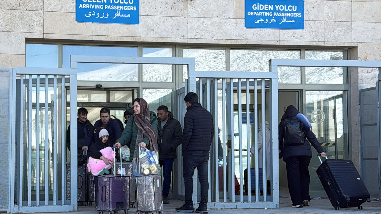 People exit and enter at the Kapikoy border crossing between Turkey and Iran, in Van province, Turkey, March 1, 2026. REUTERS/Ismet Mikailogullari