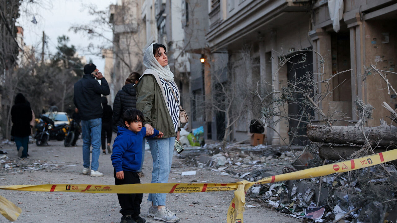 A woman with her child looks at the aftermath of an Israeli and the U.S. strike on a police station, amid the U.S.-Israel conflict with Iran, in Tehran, Iran, March 2, 2026. Majid Asgaripour/WANA (West Asia News Agency) via REUTERS