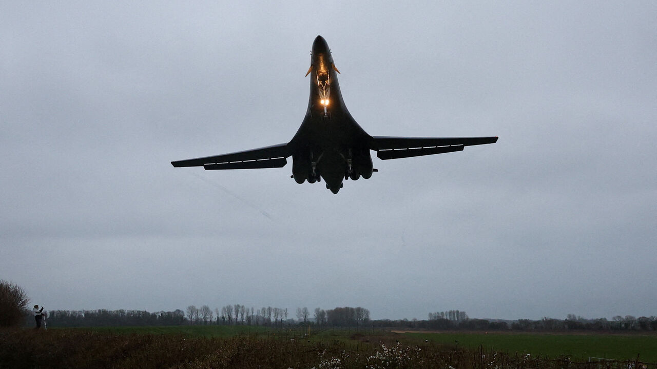 A person looks up as a USAF B1-B bomber prepares to land at RAF Fairford airbase, which also hosts United States Air Force (USAF) personnel, amid the U.S.–Israeli conflict with Iran, in Fairford, Britain, March 6, 2026. REUTERS/Toby Melville