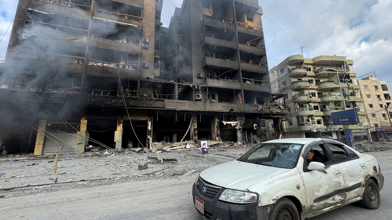 A car drives past burned buildings after an Israeli strike on Beirut's southern suburbs, following an escalation between Hezbollah and Israel amid the U.S.-Israeli conflict with Iran, Lebanon, March 7, 2026. Picture taken with a mobile phone. REUTERS/Stringer