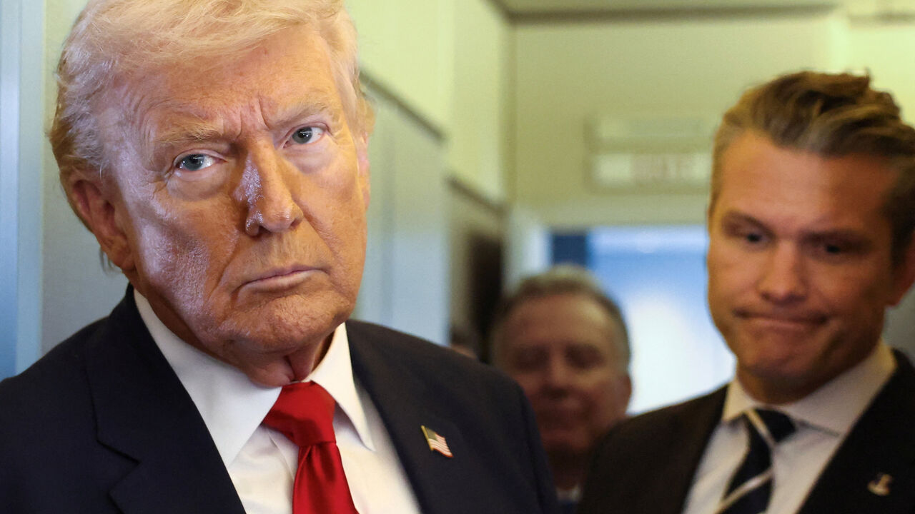 U.S. President Donald Trump, with Secretary of Defense Pete Hegseth at his side, looks on as he speaks to reporters aboard Air Force One on a flight from Dover, Delaware, to Miami, Florida, U.S., March 7, 2026. REUTERS/Kevin Lamarque