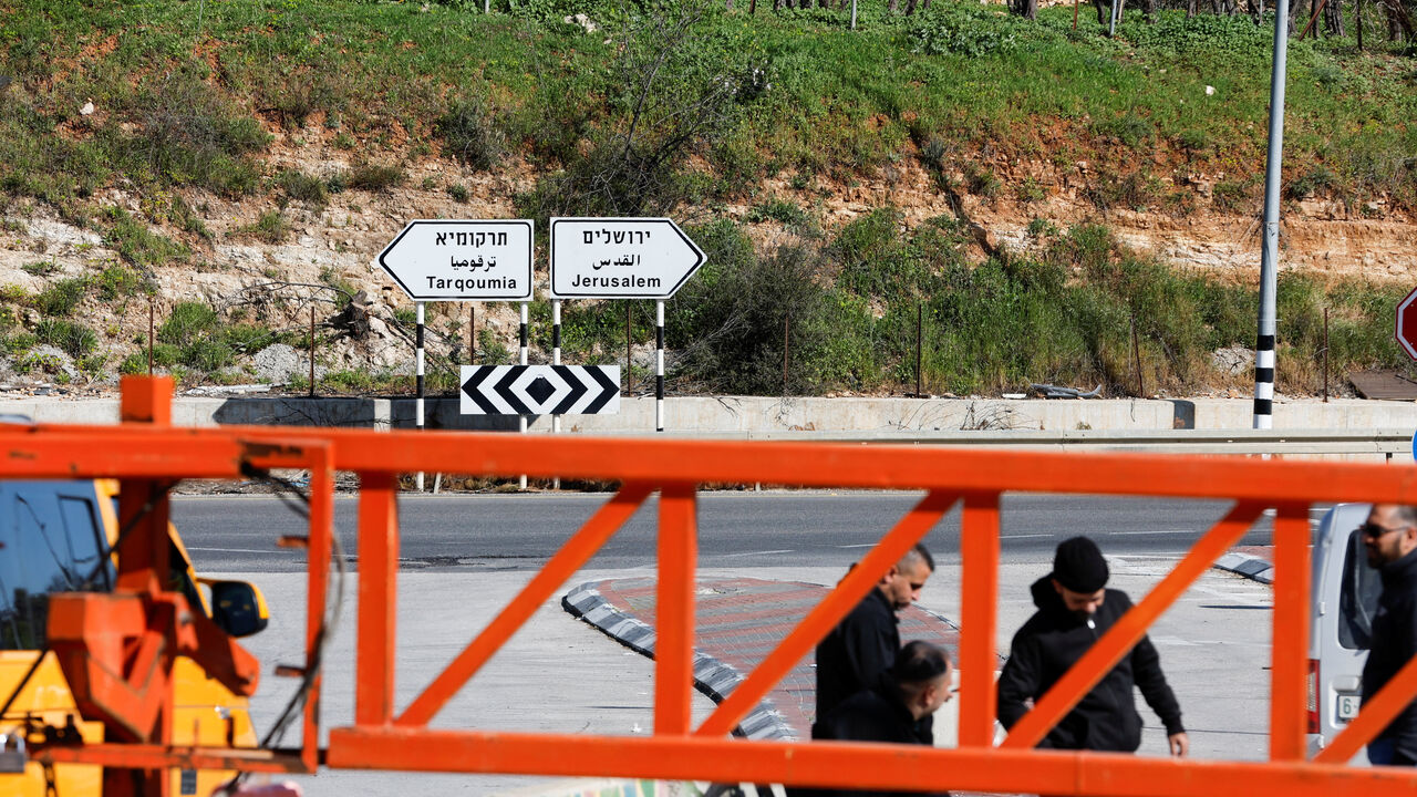 Taxi driavers wait near an Israeli gate, after Israeli forces sealed entrances to cities and villages amid heightened restrictions during the conflict with Iran, near Hebron in the Israeli-occupied West Bank, March 1, 2026. REUTERS/Mussa Qawasma