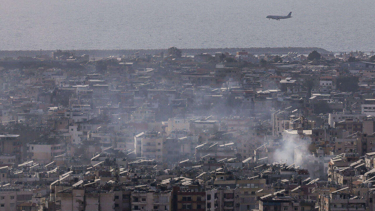 An aircraft flies as smoke rises after Israeli strikes following an escalation between Hezbollah and Israel, amid the U.S.-Israeli conflict with Iran, in the southern suburbs of Beirut, Lebanon, March 12, 2026. REUTERS/Raghed Waked