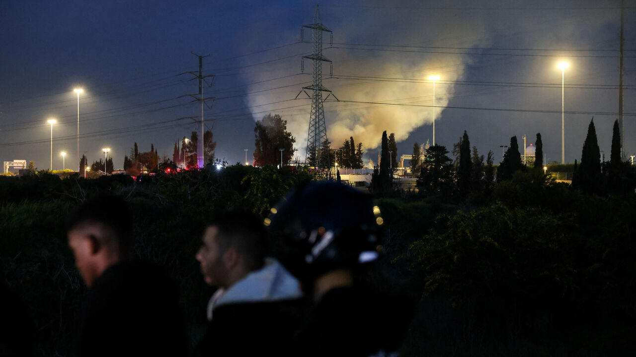 A plume of smoke rises from an impact site following an Iranian missile strike, amid the U.S.-Israeli conflict with Iran, in central Israel, March 13, 2026. REUTERS/Tyrone Siu