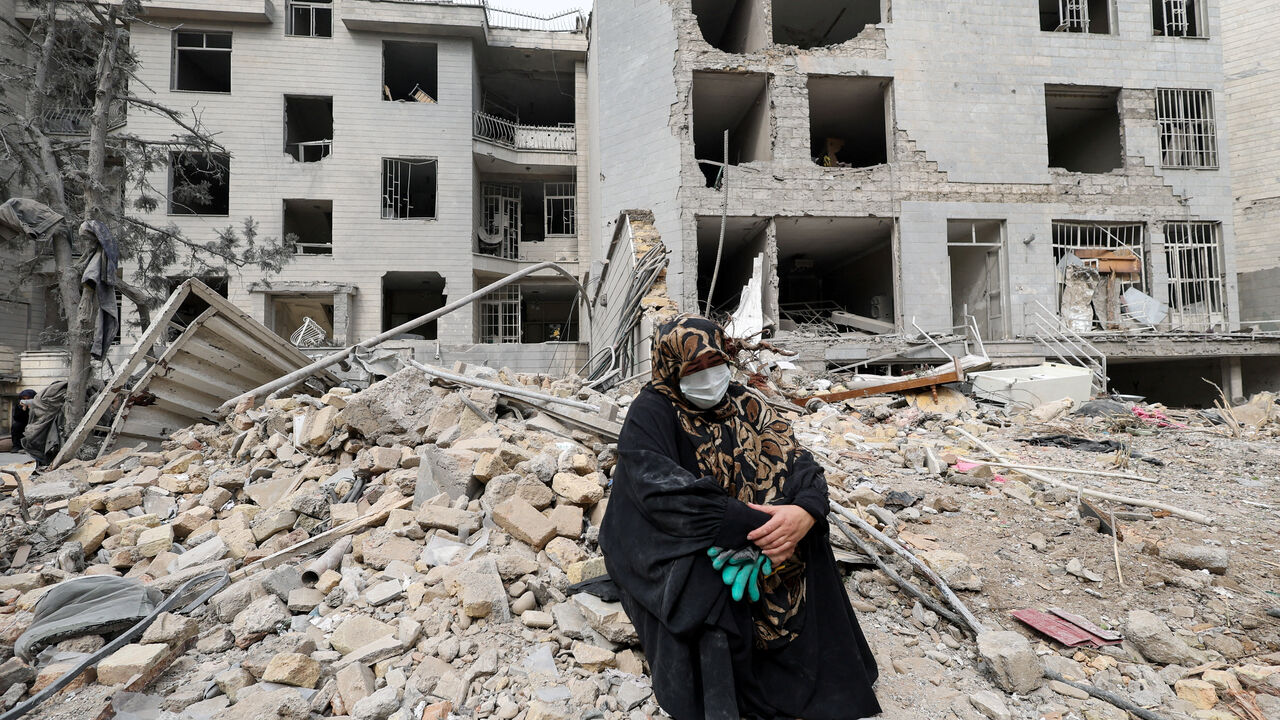 A woman sits outside her destroyed apartment after it was damaged by an airstrike while she was inside, amid the U.S.-Israeli conflict with Iran, in Tehran, Iran, March 12, 2026. REUTERS/Alaa Al Marjani
