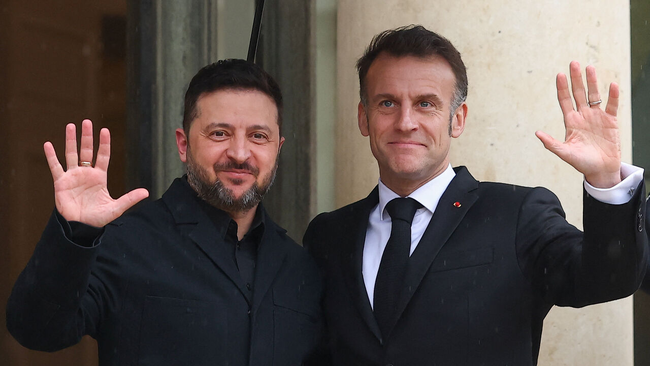French President Emmanuel Macron and Ukrainian President Volodymyr Zelenskiy wave, as President Zelenskiy arrives for a meeting at the Elysee Palace in Paris, France, March 13, 2026. REUTERS/Gonzalo Fuentes