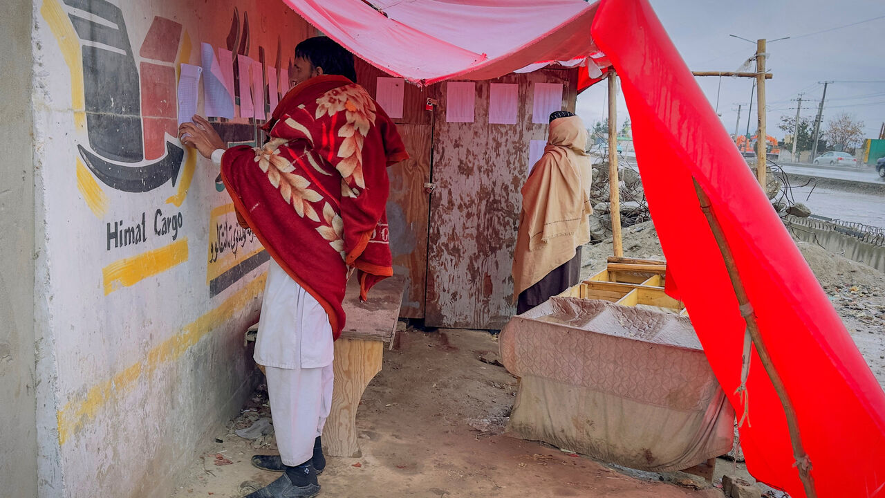 Afghan men search for the names of missing relatives on a list at the site of a drug rehabilitation center destroyed in what the Taliban said was a Pakistani airstrike in Kabul, Afghanistan, March 18, 2026. REUTERS/Sayed Hassib