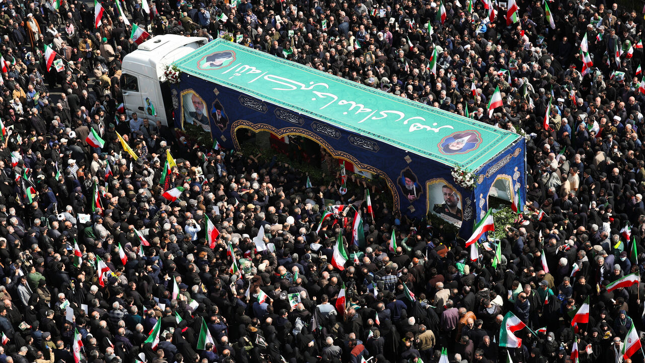 People gather around the coffin of Iranian security chief Ali Larijani during a funeral for Larijani and victims of the IRIS Dena warship at Enghelab Square, amid the U.S.-Israeli conflict with Iran, in Tehran, Iran, March 18, 2026. REUTERS/Alaa Al Marjani