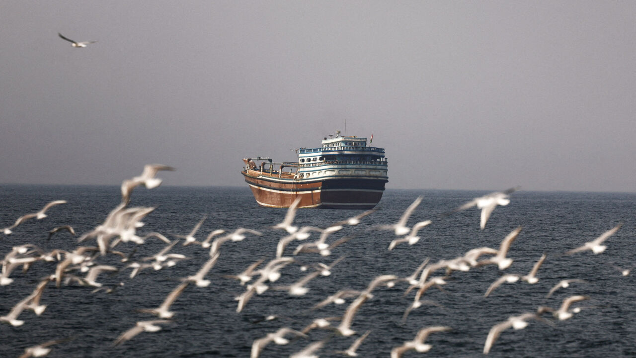 FILE PHOTO: Birds fly near a boat in the Strait of Hormuz amid the U.S.-Israeli conflict with Iran, as seen from Musandam, Oman, March 2, 2026.REUTERS/Amr Alfiky/File Photo