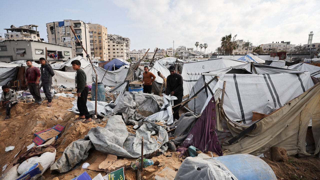 Palestinians inspect the site of Wednesday’s Israeli strike on a tent camp sheltering displaced Palestinians, in Gaza City, March 12, 2026. The Israeli military ordered the camp to evacuate before the strike. REUTERS/Dawoud Abu Alkas