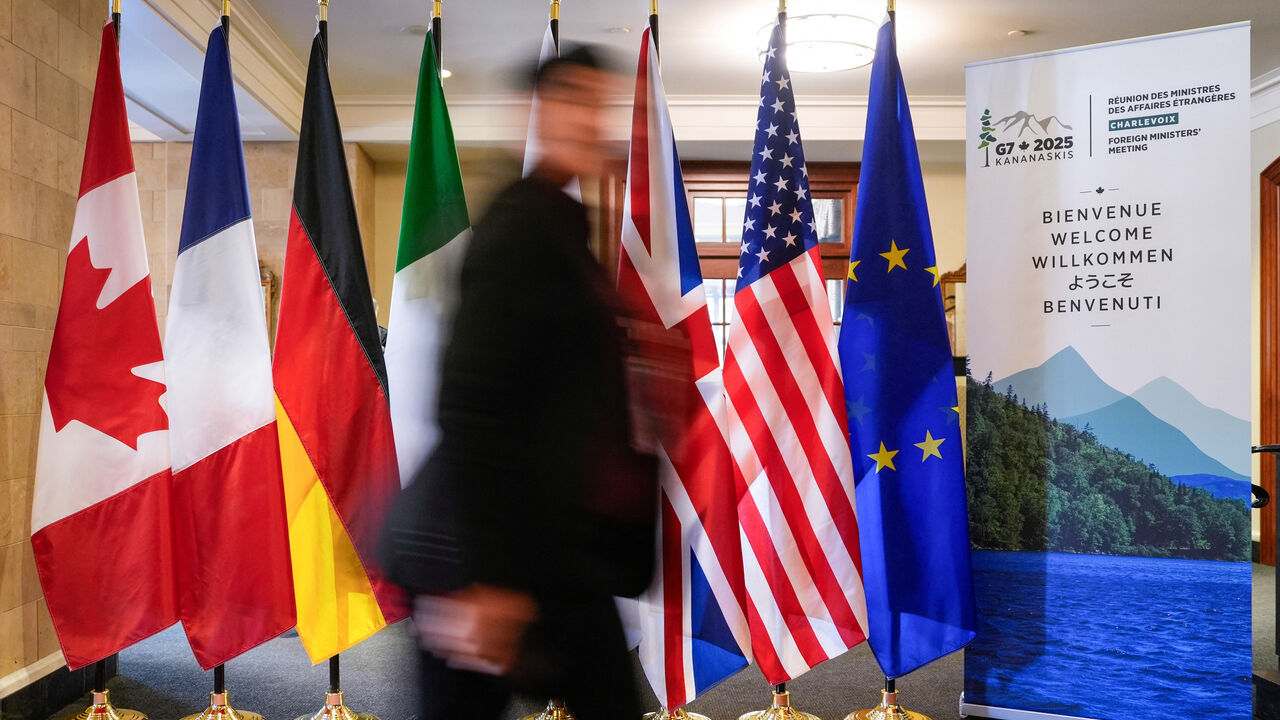 A man walk past the G7 members flags at the Manoir Richelieu before the G7 Foreign Ministers summit in La Malbaie, Quebec, Canada March 12, 2025.  REUTERS/Mathieu Belanger