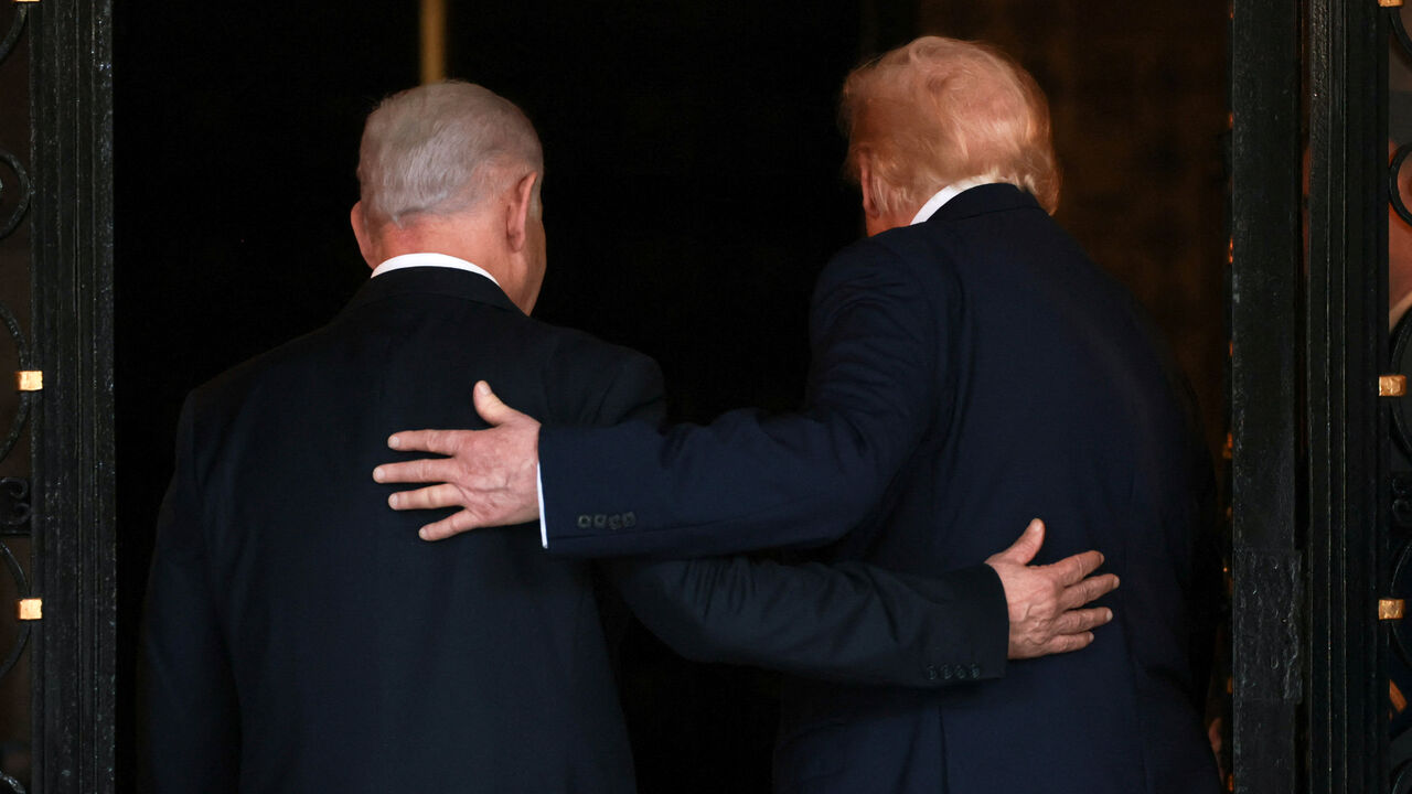 U.S. President Donald Trump and Israeli Prime Minister Benjamin Netanyahu embrace as they walk into Trump's Mar-a-Lago club in Palm Beach, Florida, U.S., December 29, 2025. REUTERS/Jonathan Ernst/File Photo