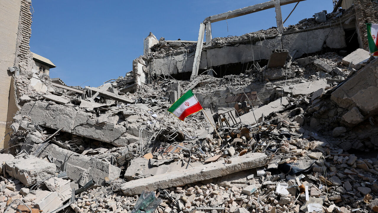 An Iranian flag stands in the rubble following a strike on a police station in Tehran, Iran, March 4.   Majid Asgaripour/WANA