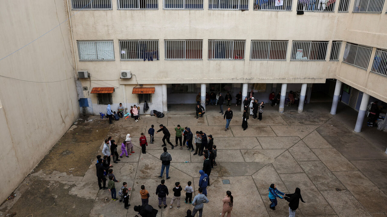 Children play at the yard of a school used as a temporary shelter for displaced people, following an escalation between Hezbollah and Israel, amid the U.S.-Israeli conflict with Iran, in Beirut, Lebanon, March 23, 2026. REUTERS/Mohamed Azakir