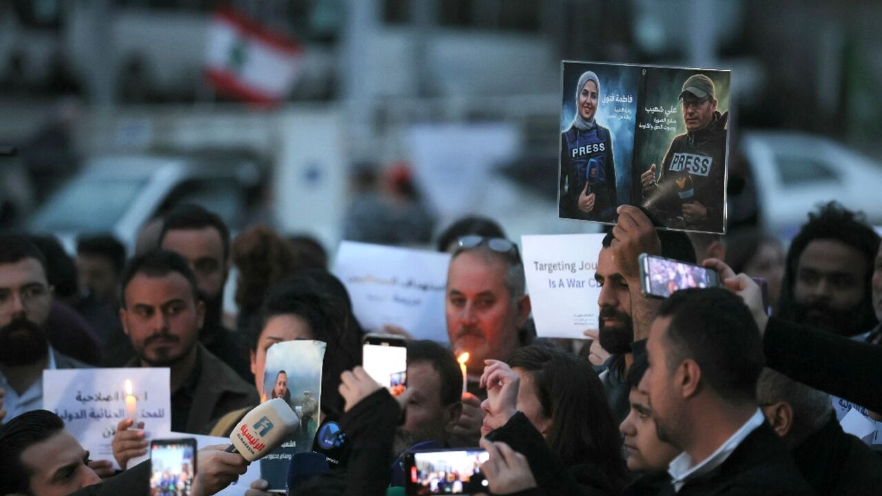 A Lebanese journalist holds pictures of Shoeib and Ftouni at a protest against their killing