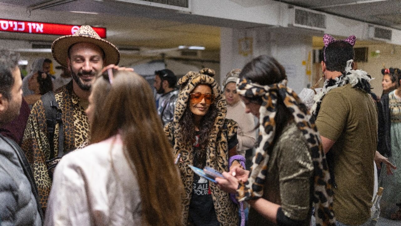 Israelis dressed in costumes gather in a parking lot used as an air raid shelter to celebrate the festive Purim