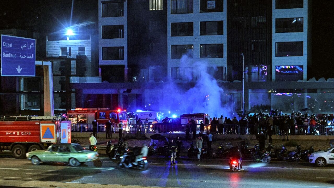 Rescuers rush to the site of an Israeli strike on a vehicle along the highway leading to Beirut's international airport