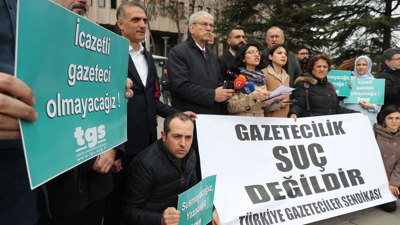 Journalists gather outside the Ankara courthouse on March 10, 2020 behind a banner reading in Turkish "journalism is not crime," to protest over jailing of journalists, sparked by the recent arrest of OdaTV's news director and a journalist's report on the funeral of a Turkish intelligence officer apparently killed in Libya. 