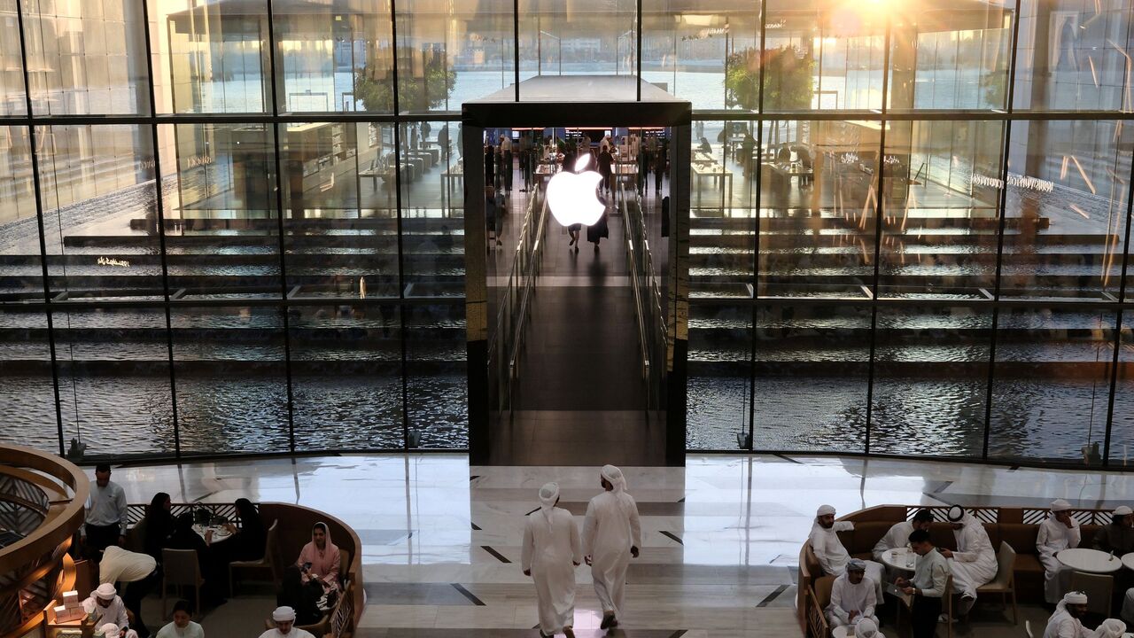 People sit in a cafe outside the Apple Store in Dubai on May 8, 2025.