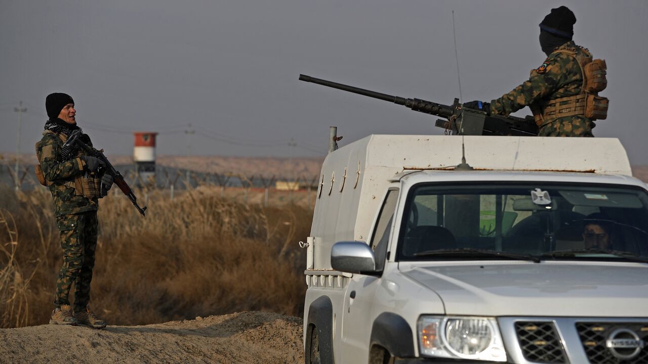 Members of the Popular Mobilization Units stand guard along the Iraqi-Syrian border in Al-Qaim, west of Iraq, on Jan. 23, 2026. 
