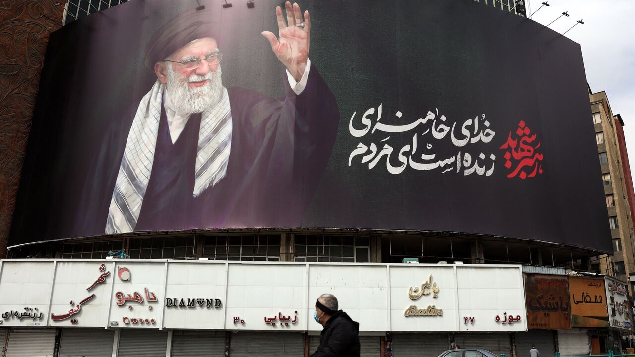 A man rides a motorbike past a billboard of Iran's supreme leader, Ayatollah Ali Khamenei, in Tehran on March 2, 2026. 