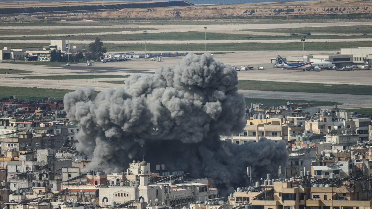 Smoke rises from the site of an Israeli airstrike that targeted the Al Lailaki neighborhood in Beirut's southern suburbs, with the city's International Airport visible in the background, on March 4, 2026. 
