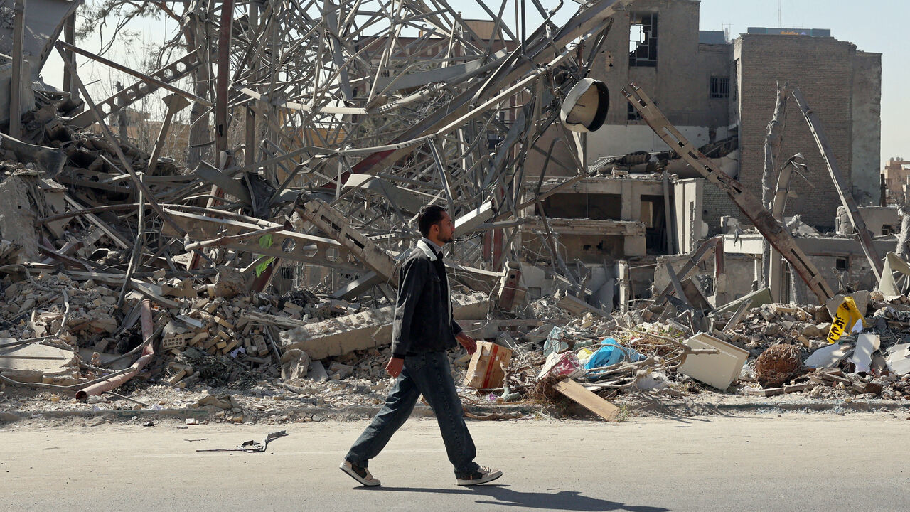 A man walks past destroyed buildings following airstrikes in central Tehran on March 4, 2026. 