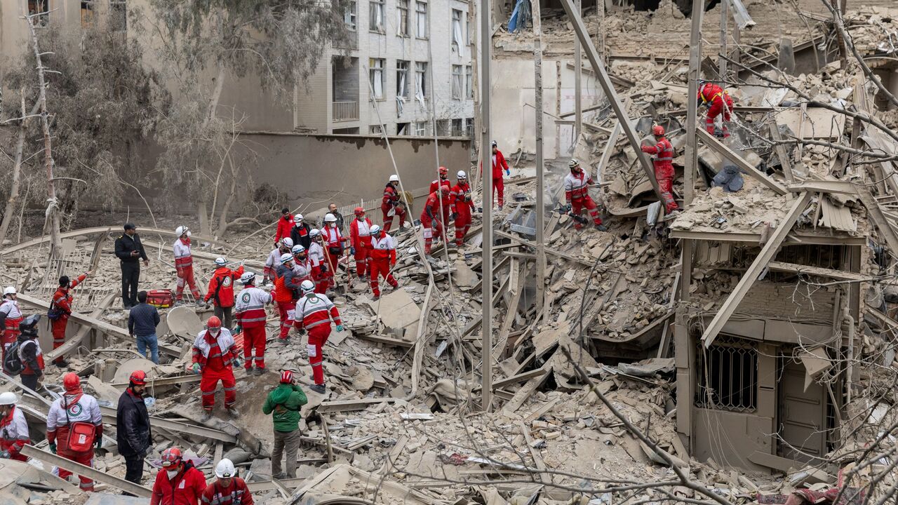 Emergency crews search for people trapped in rubble following a strike on a residential building on March 16, 2026 in central Tehran, Iran. 