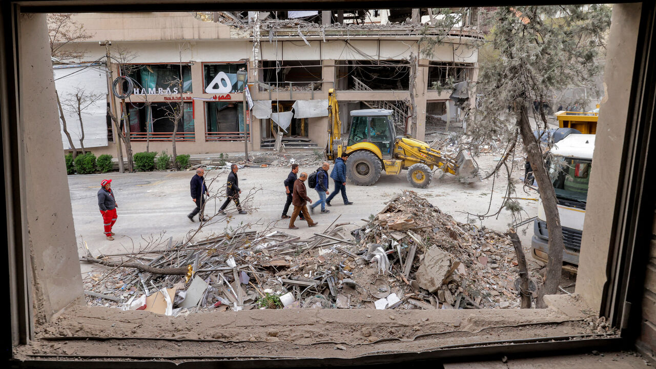 People inspect destruction at a business building that housed the offices of the Doha-headquartered news network Al Araby TV following a missile strike earlier in the day, Tehran, Iran, March 29, 2026.