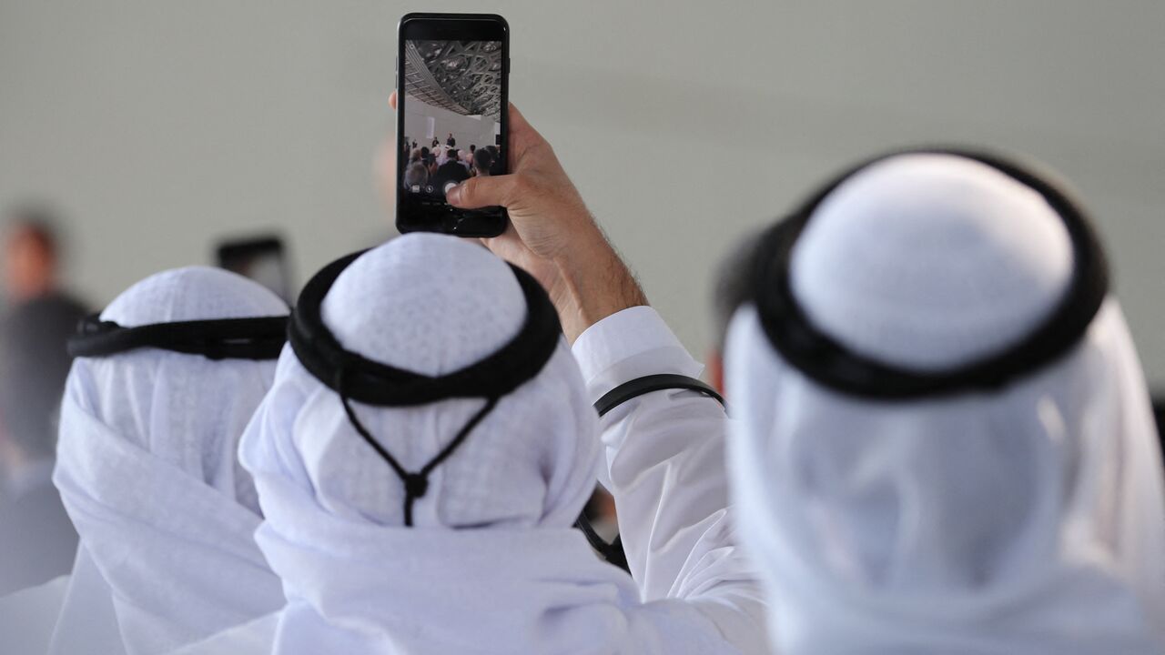 Attendees take a picture of French Prime Minister Edouard Philippe as he delivers a speech during a visit to the Louvre Abu Dhabi Museum on February 10, 2018, on Saadiyat island in the Emirati capital, to launch the French-Emirati "Year of Cultural Dialogue". (Photo by KARIM SAHIB / AFP) (Photo by KARIM SAHIB/AFP via Getty Images)