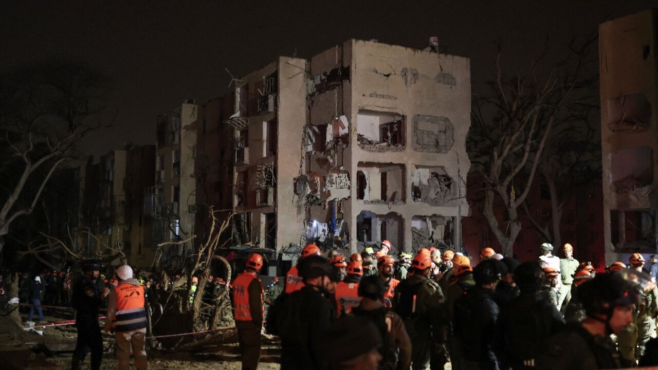 First responders inspect the site of an Iranian missile strike in the Israeli town of Arad on March 22, 2026