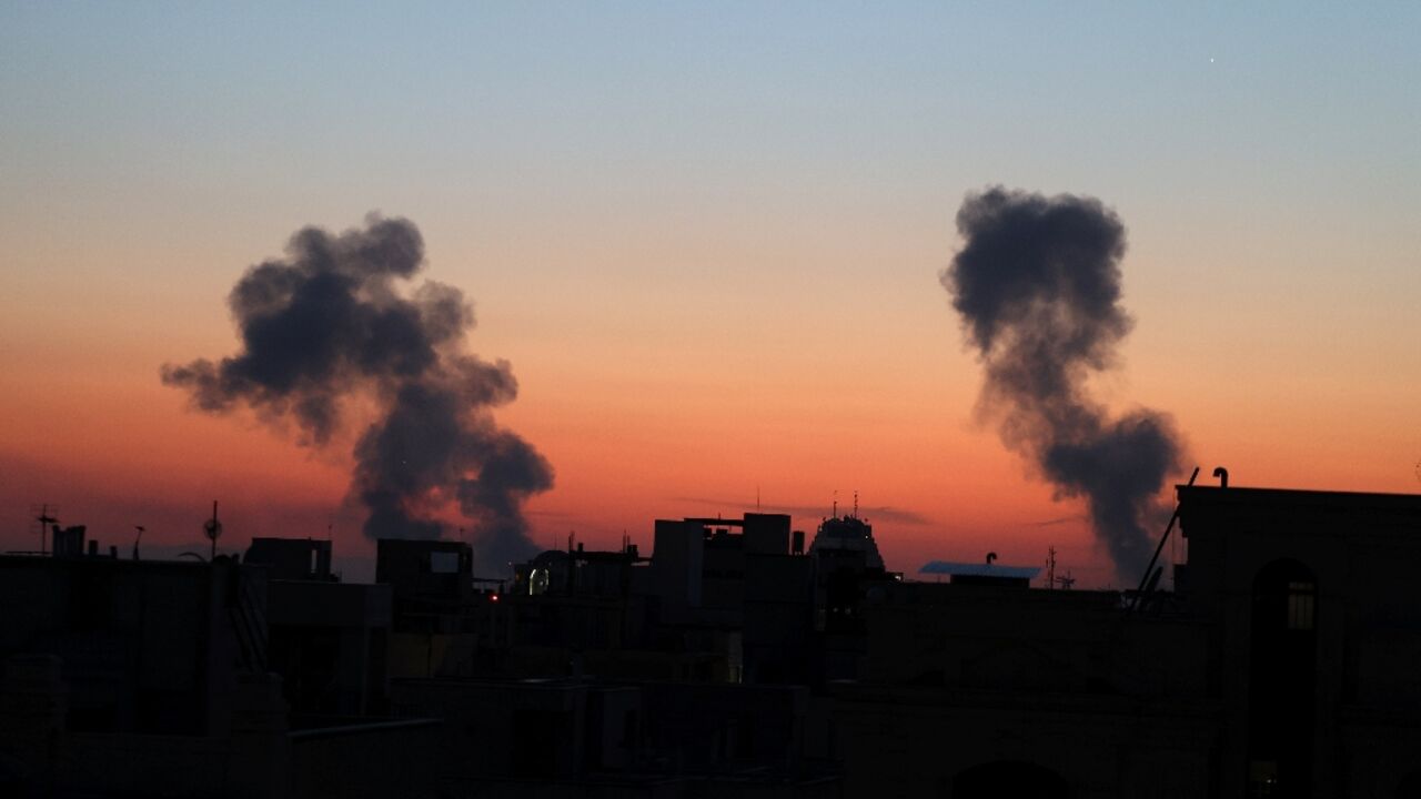 Black plumes of smoke ascend from the site of airstrikes on Friday in a central area of the Iranian capital Tehran