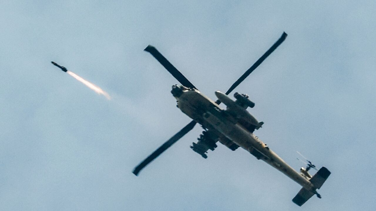 An Israeli air force AH-64 Apache attack helicopter fires rockets while flying along the border with Lebanon 
