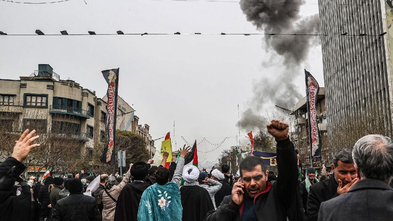 Black smoke rises after an airstrike in Tehran as Iranians take part in the Al-Quds (Jerusalem) Day rally on March 13, 2026
