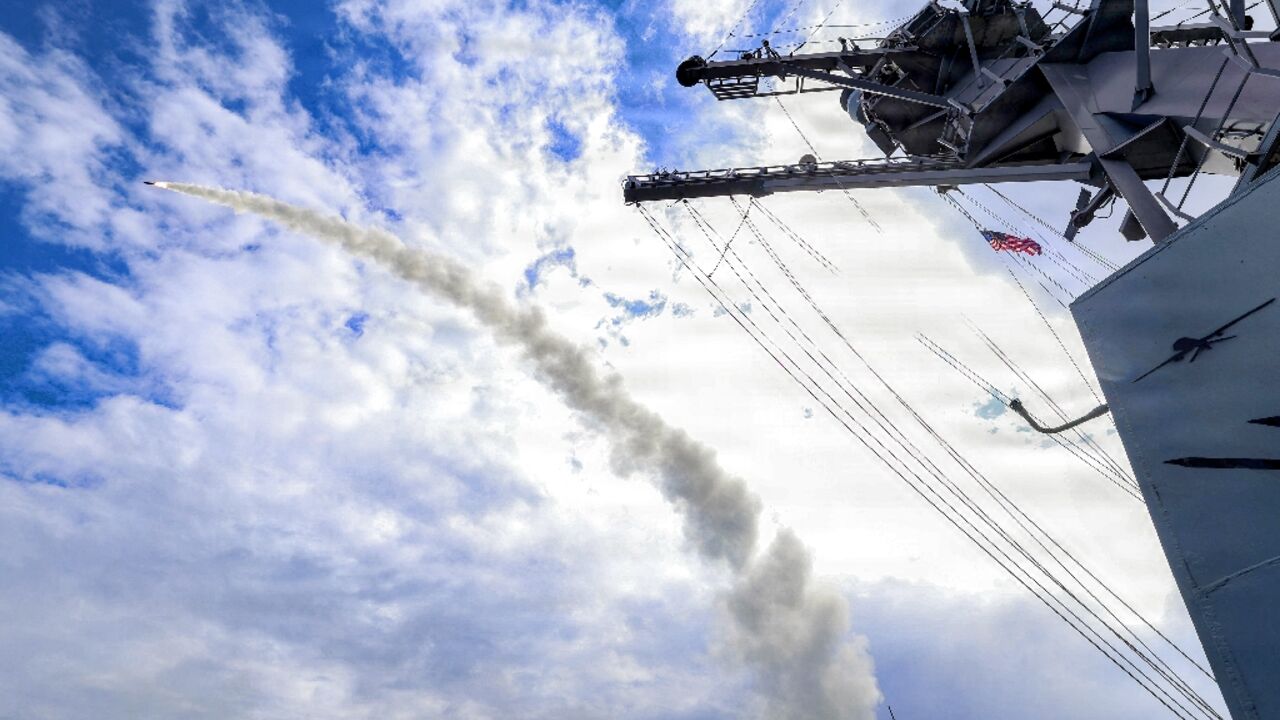 This US Navy handout photo shows the Arleigh Burke-class guided-missile destroyer USS Thomas Hudner (DDG 116) firing a Tomahawk land attack missile in support of Operation Epic Fury