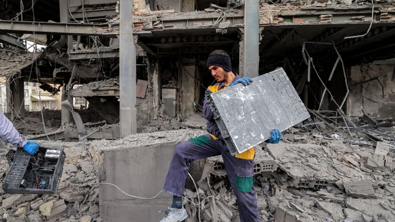 A man retrieves equipment from an office building in Tehran recently hit by a strike