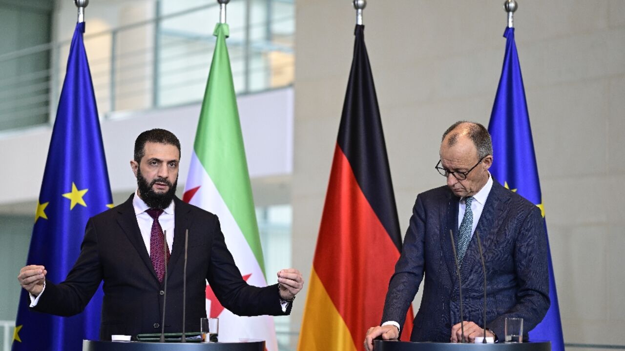 German Chancellor Friedrich Merz (R) and Syrian President Ahmed al-Sharaa address a joint press conference