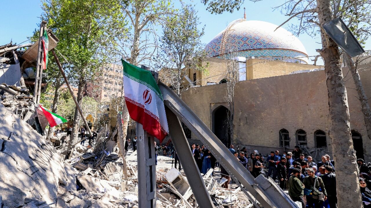 Journalists film outside a damaged mosque following strikes on Sharif University of Technology in Tehran on April 7, 2026