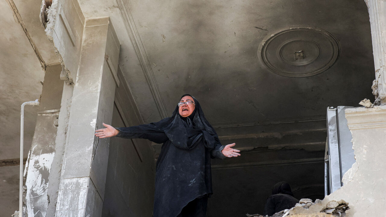 A woman reacts inside her brother's home, which was damaged by an airstrike, in Tehran, Iran, March 30.  Majid Asgaripour/WANA