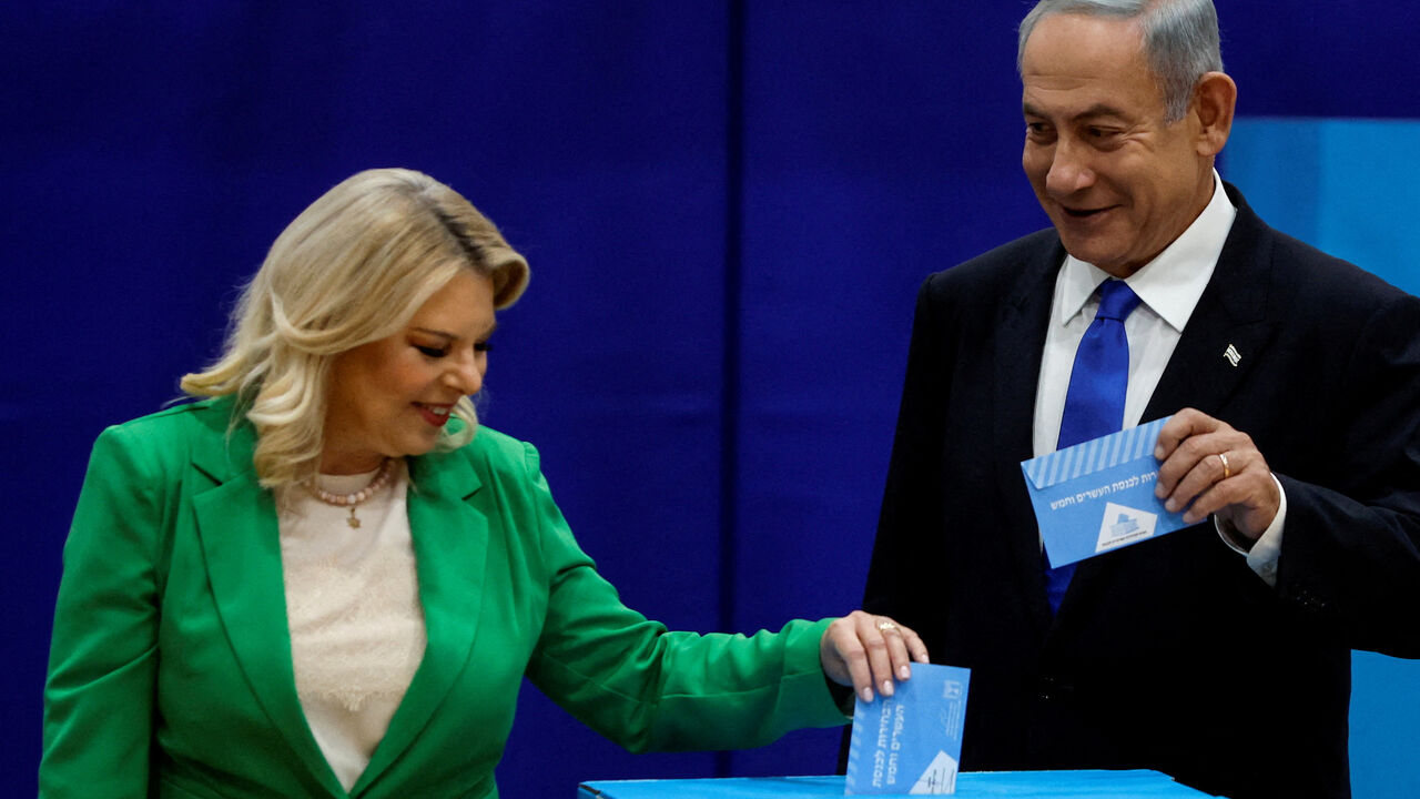 FILE PHOTO: Former Israeli Prime Minister Benjamin Netanyahu stands next to his wife Sara as they cast their ballots on the day of Israel's general election in a polling station in Jerusalem November 1, 2022. REUTERS/Ammar Awad/File Photo