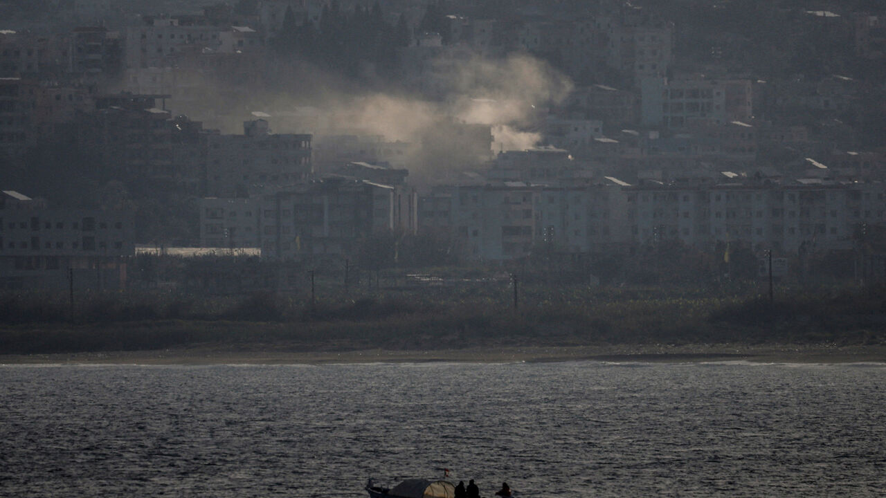 FILE PHOTO: Fishermen sail their boat as smoke from an Israeli airstrike rises in Abbassiye area in Tyre, Lebanon, April 14, 2026. REUTERS/Louisa Gouliamaki/File Photo