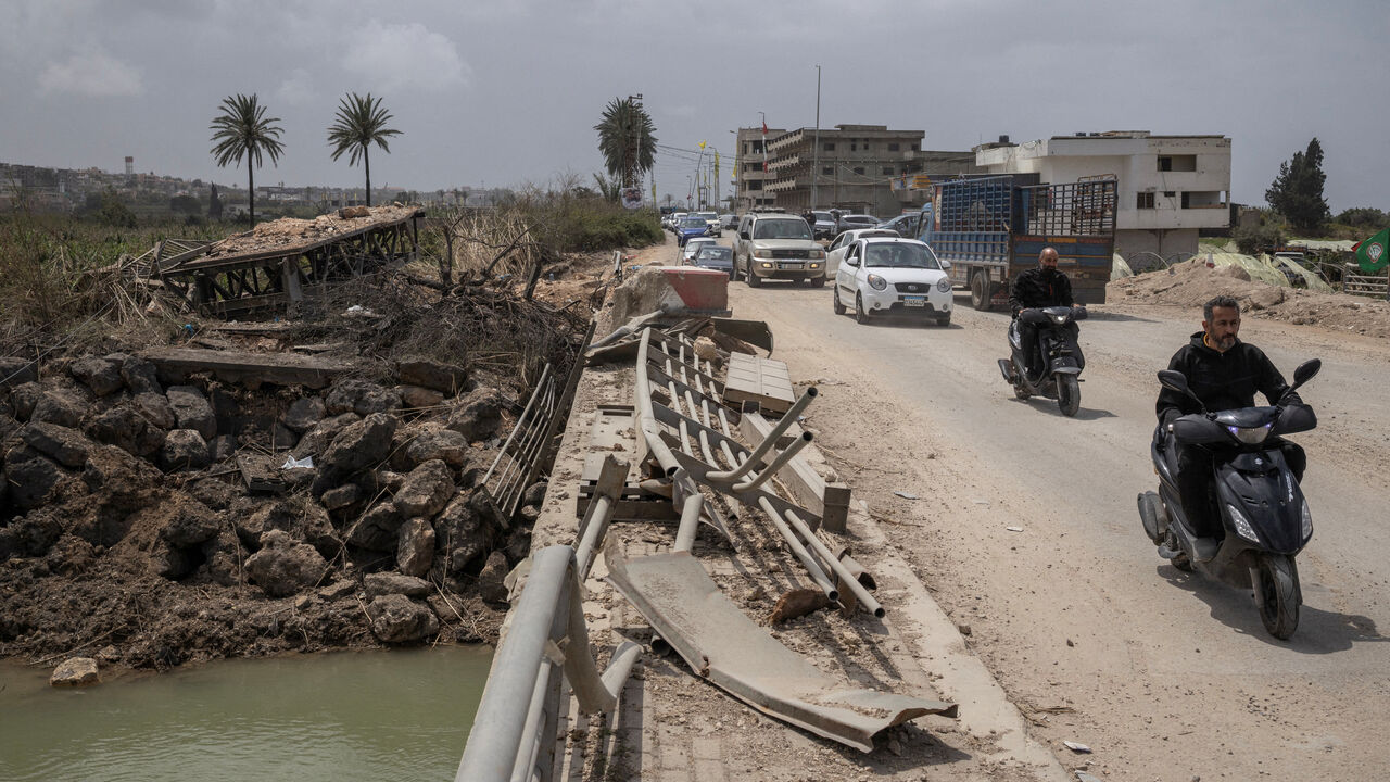 People travel in vehicles as displaced people make their way back to their homes, crossing the bridge linking southern Lebanon to the rest of the country, which was hit earlier in an Israeli strike, in Qasmiyeh, Lebanon, April 19.  REUTERS/Marko Djurica
