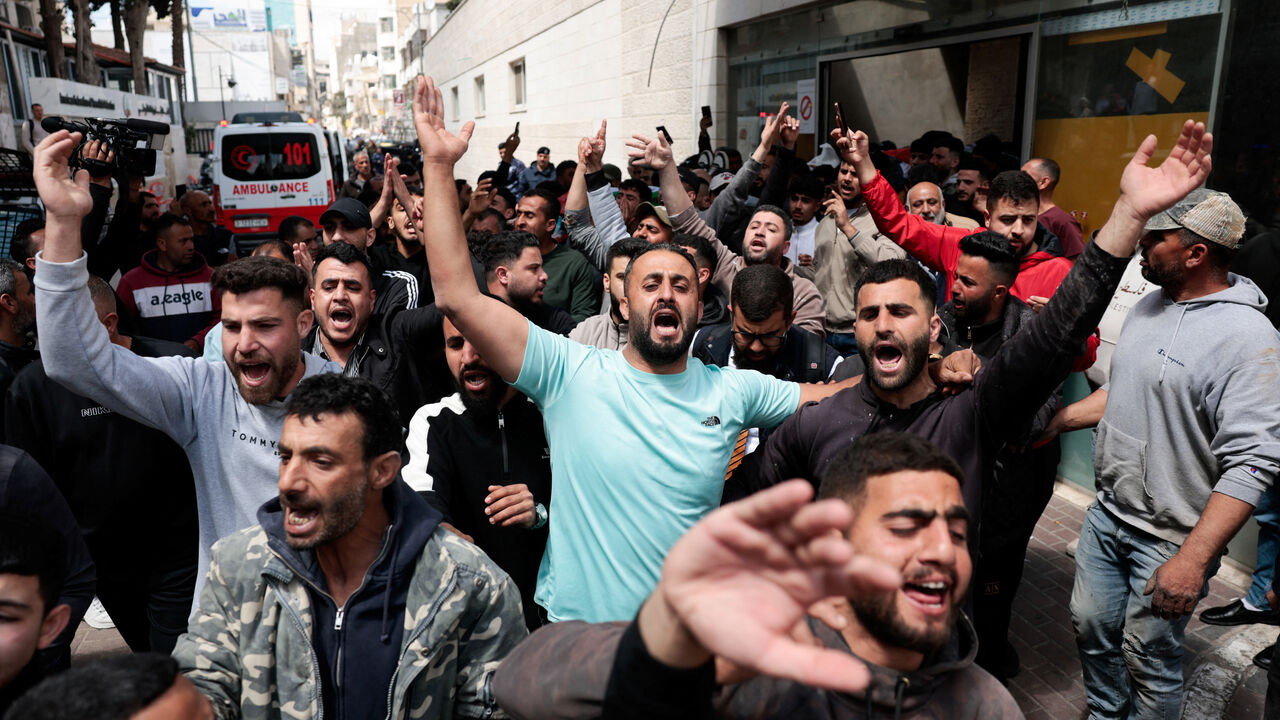 People react as the bodies of two Palestinians, who were killed during what the Palestinians said was an Israeli settler attack in Al-Mughayir village near Ramallah, are carried at a hospital in Ramallah, in the Israeli-occupied West Bank, April 21, 2026. REUTERS/Mohammed Torokman