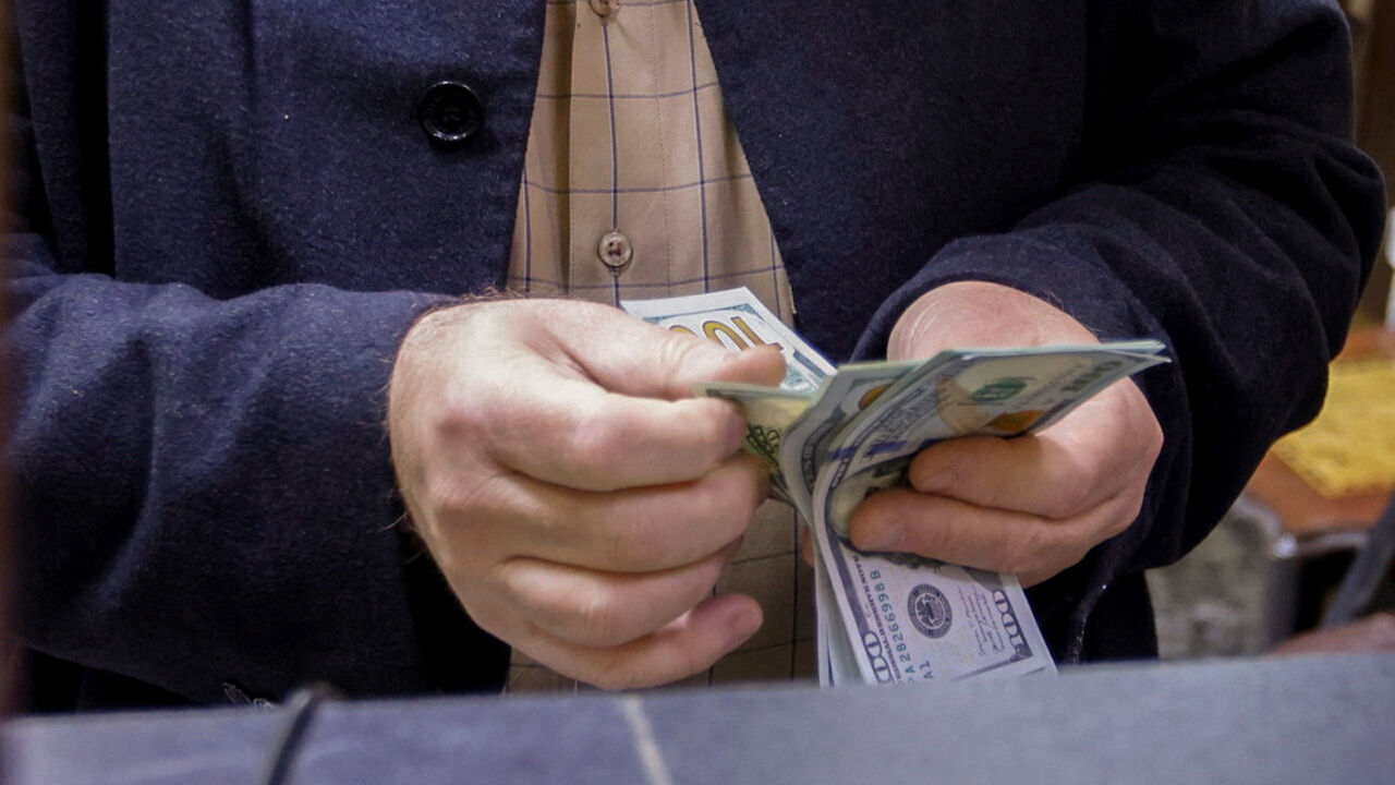 FILE PHOTO: A man counts U.S. dollars at a currency exchange shop in Baghdad, Iraq, January 23, 2023. REUTERS/Ahmed Saad/ File Photo