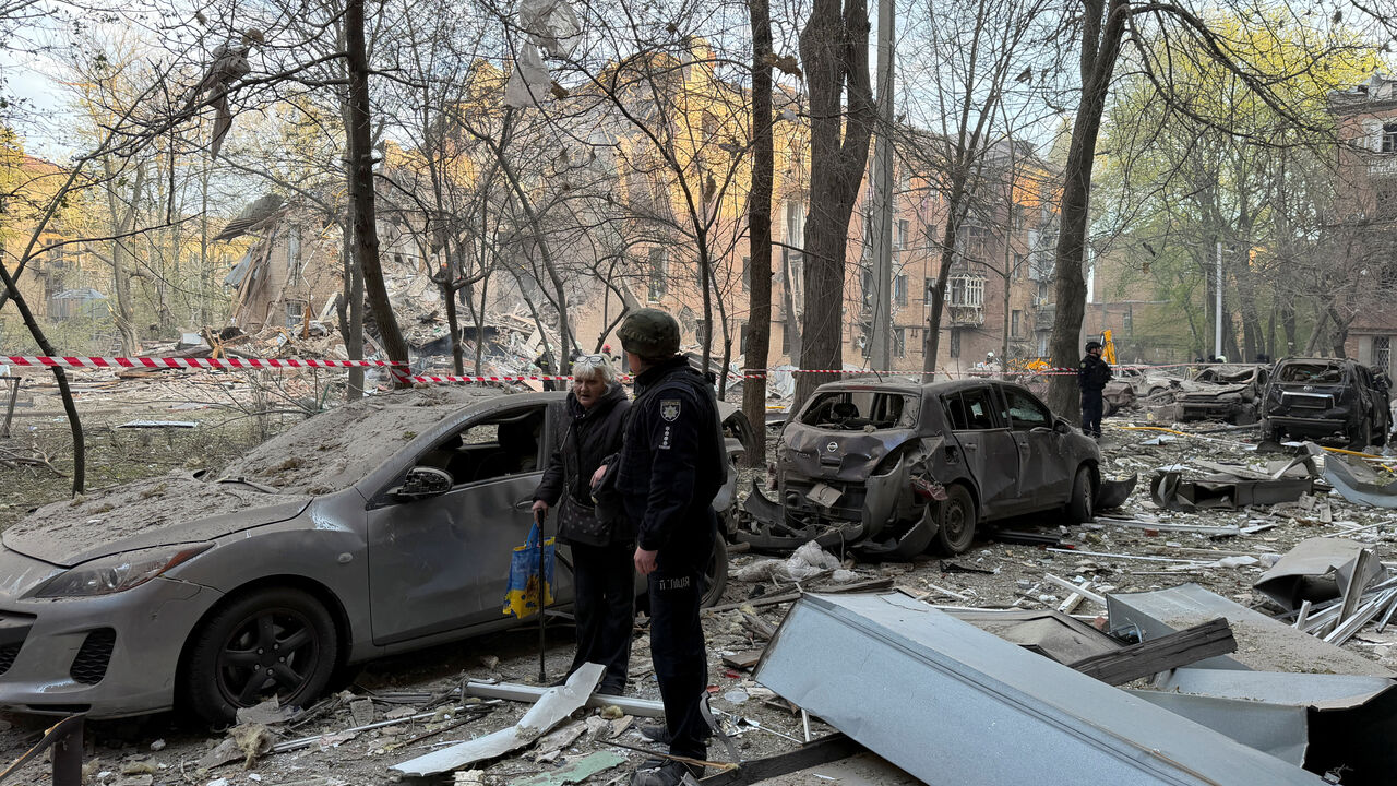 A police officer evacuates a resident at a site of an apartment building hit by a Russian drone and missile strike, amid Russia's attack on Ukraine, in Dnipro, Ukraine April 25, 2026. Picture taken using a mobile phone. REUTERS/Serhii Chalyi