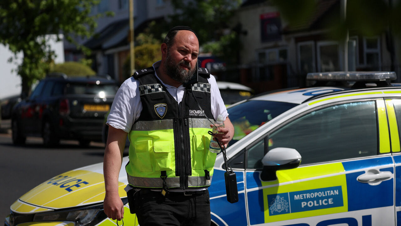 A Shomrim London Emergency Support Unit member stands by a police vehicle in Golders Green, after a man was arrested following a stabbing incident in the area, which is home to a large Jewish population, in London, Britain, April 29, 2026. REUTERS/Hannah McKay