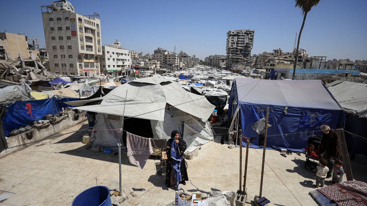 A displaced Palestinian woman stands among tents at a camp for displaced people in Gaza City, April 28, 2026. REUTERS/Dawoud Abu Alkas