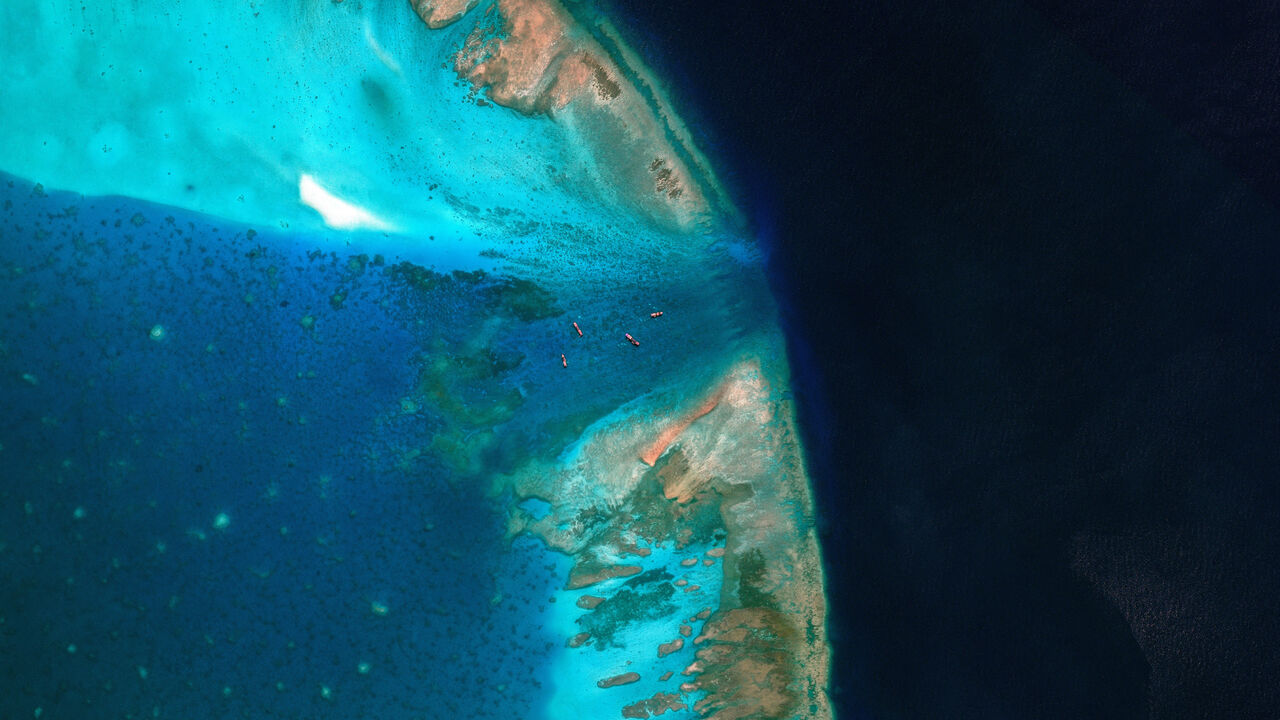 A satellite image of fishing vessels at the entrance, which is blocked by a floating barrier, to the disputed Scarborough Shoal, in the South China Sea, April 11, 2026. Vantor/Handout via REUTERS